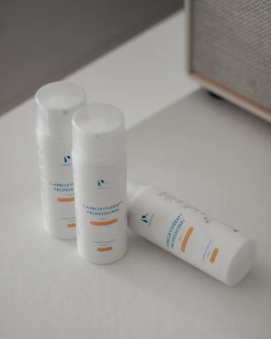 Three unbranded white cosmetic bottles photographed on a clean white background.