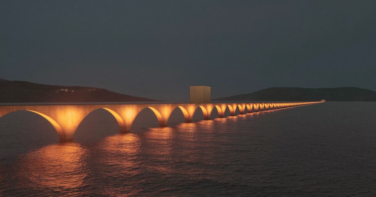 A long arched bridge lit warm orange crossing a dark calm sea between two headlands at dusk, with one small plain parcel on the deck, illustrating goods crossing from the UK to the EU.