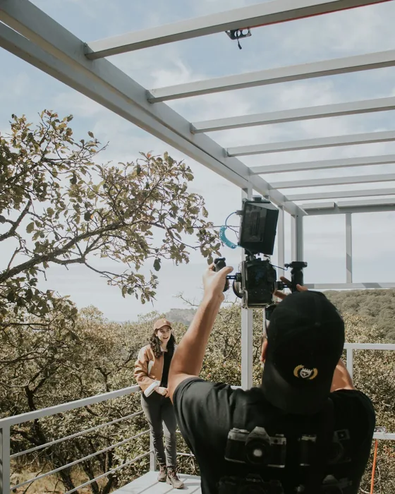 A camera operator filming a person outdoors on a cinema camera.